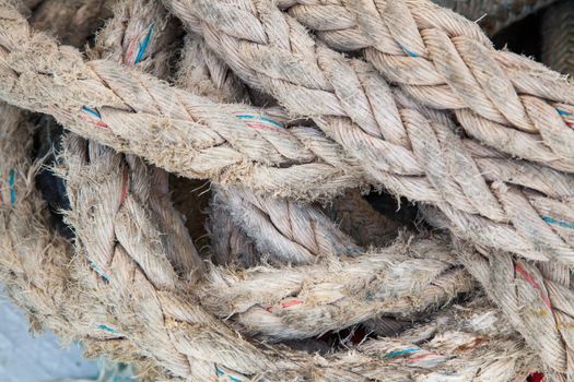 Hanged weathered boat ropes on a blue sea