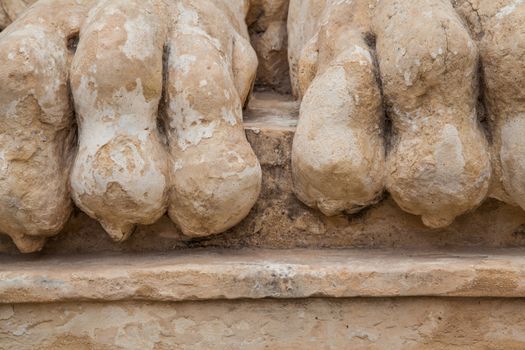 Rocky and ancient lion feet damaged by the weather