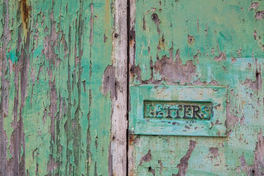 Green weathered wood door with letterbox