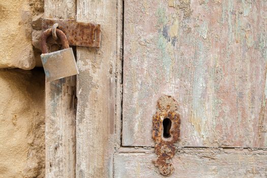 Ancient wood door with rusty lock and keyhole