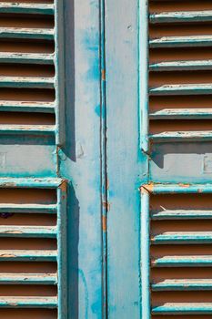 A cyan rusty window made with wood panel