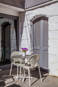 A table with two chairs in front of a grey door