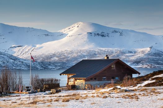 Isolated home and beach on a snowy lake