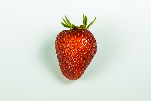 Juicy red strawberry on a white table