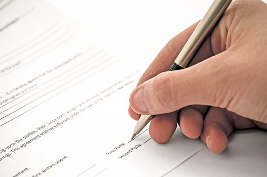 Close-up view of a man signing a contract.