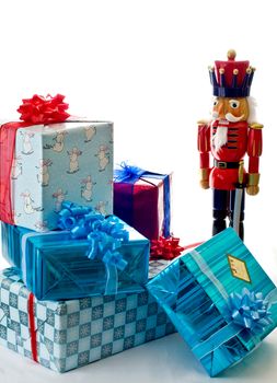 An  oversized nutcracker stands near a small pile of presents.