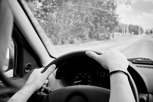 Woman driving, view inside a car on a road