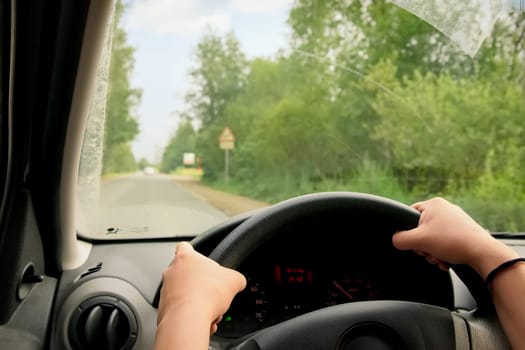 Woman driving, view inside a car on a road