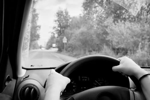 Woman driving, view inside a car on a road