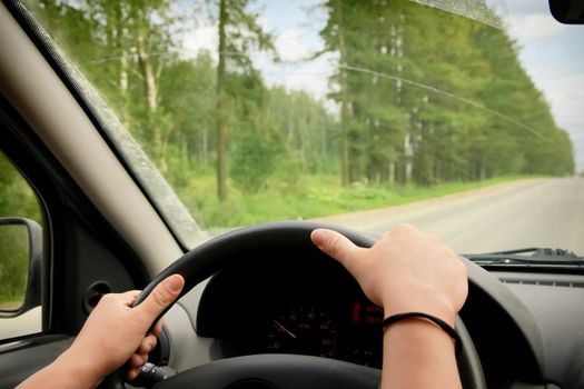 Woman driving, view inside a car on a road