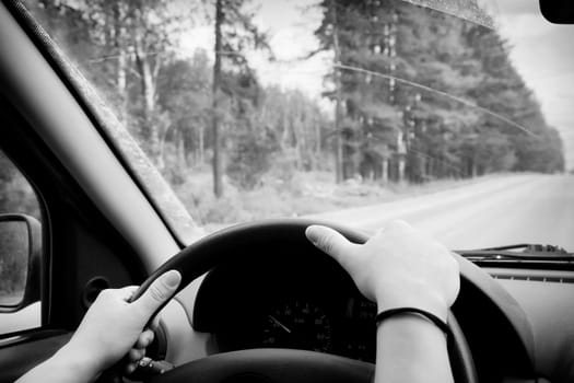 Woman driving, view inside a car on a road