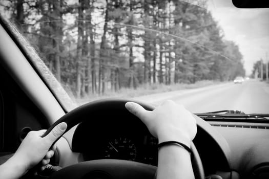 Woman driving, view inside a car on a road