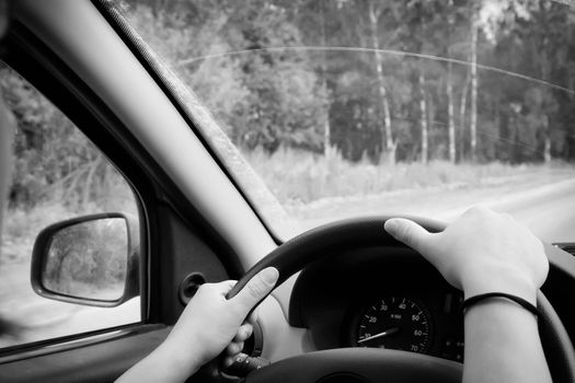 Woman driving, view inside a car on a road