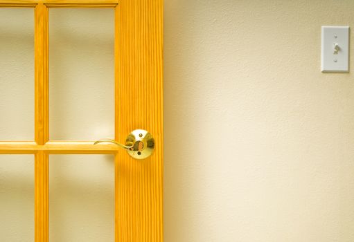 A section of wall with an open door and light switch