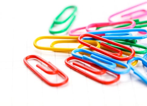 colored paper clips close-up on white background