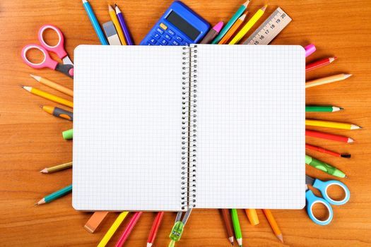 notebook, pencils, scissors, calculator, ruler, compass, pen on wooden background