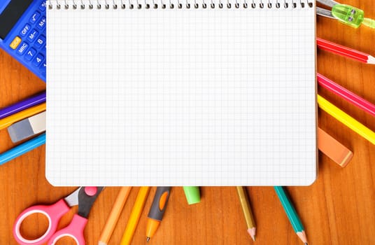notebook, pencils, scissors, calculator, ruler, compass, pen on wooden background