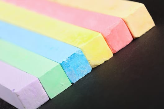 set of colored crayons on a black background