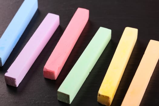 set of colored crayons on a black background