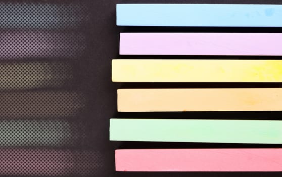 set of colored crayons on a black background
