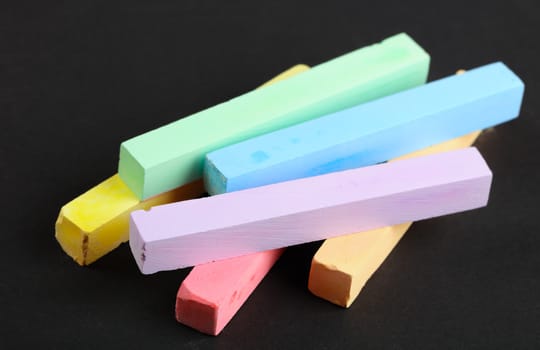 set of colored crayons on a black background