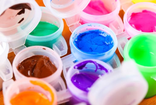 set of colorful paints close-up on wooden background