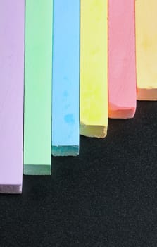 set of colored crayons on a black background