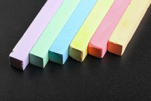 set of colored crayons on a black background