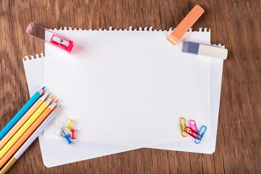 colored pencils with sheets of paper, paperclips, buttons, eraser and sharpener