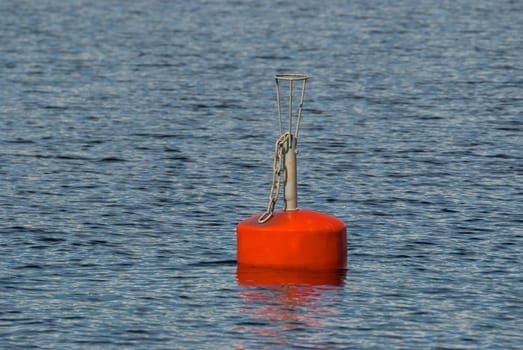 Flashing red buoy on the water surface of lake Saimaa in the Finnish city of Imatra.
