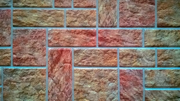 Wall, lined with colored square tiles in shades of pink.