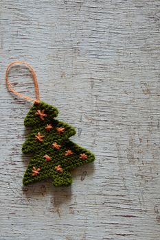 Knitted xmas tree on wooden background, Christmas trees knit from green yarn for holiday season