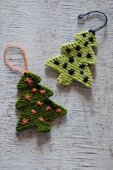 Knitted xmas tree on wooden background, Christmas trees knit from green yarn for holiday season