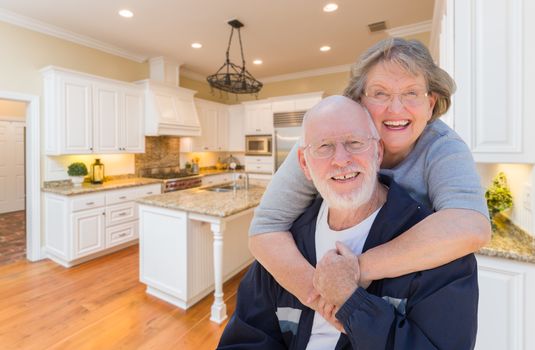 Happy Loving Senior Couple Hugging Inside Custom Kitchen.