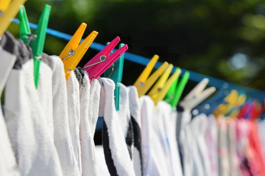 Drying clothes hanged on the clothesline securing with color clothespins.