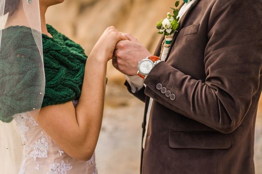 the bride and groom to hold hands, wedding rings