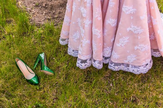 wedding emerald bridesmaid shoes on the green grass on the background of the dress