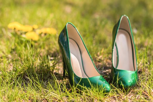 wedding emerald bridesmaid shoes on the green grass on the background of the dress