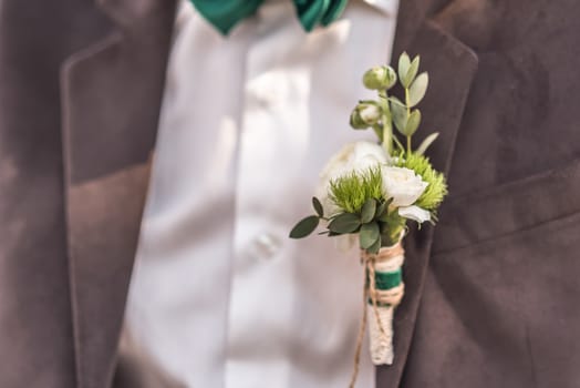 wedding boutonniere their flowers on the jacket of the groom