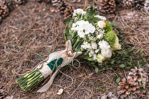 wedding bouquet on the ground on spruce litter around cones