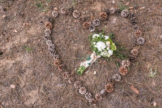 wedding bouquet on the ground on spruce litter around cones