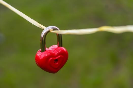 wedding decor, red lock in the shape of a heart dangling on a rope