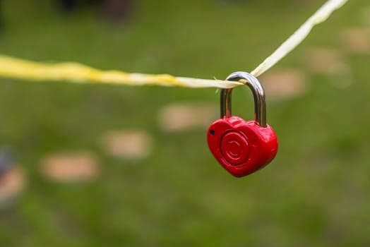 wedding decor, red lock in the shape of a heart dangling on a rope