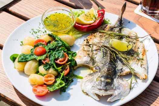 Fresh fish sea bream, bream with salt, herbs and pepper prepares grilled.