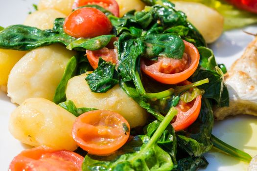 Vegetarian food, potatoes with spinach and tomatoes.