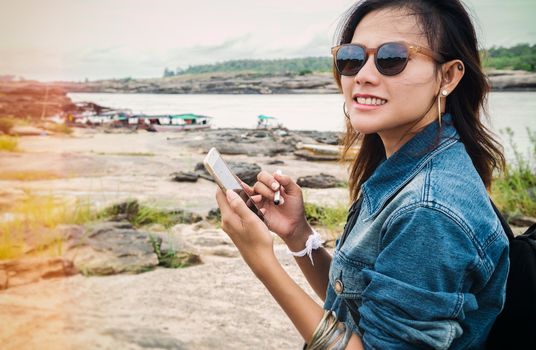 Asian women have used maps from a mobile phone with  joyful mood.