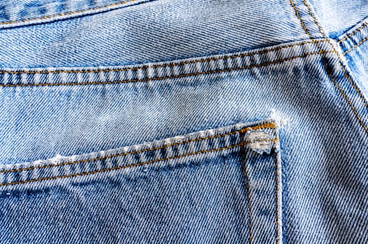 Close up back pocket of old denim jean texture.