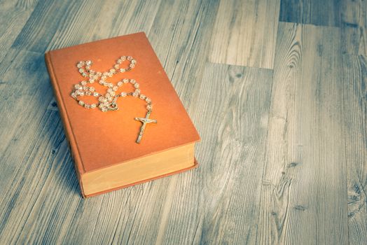 vintage rosary beads on old books