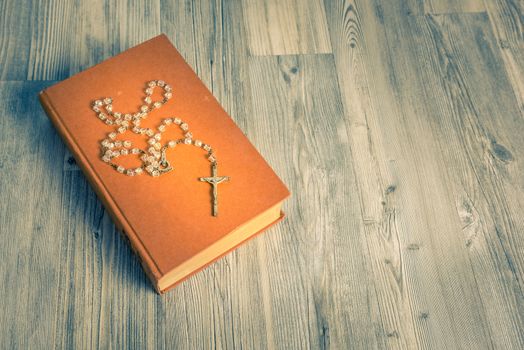 vintage rosary beads on old books, view above.