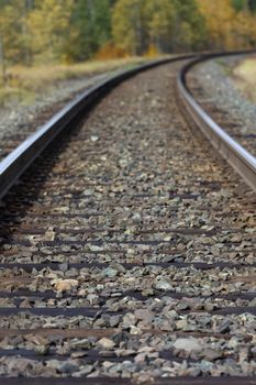 Graceful, metaphoric curve of railroad tracks with focus in foreground and unfocused distance representative of journey with unknowns ahead.  Location is British Columbia, Canada, along Highway 16.  